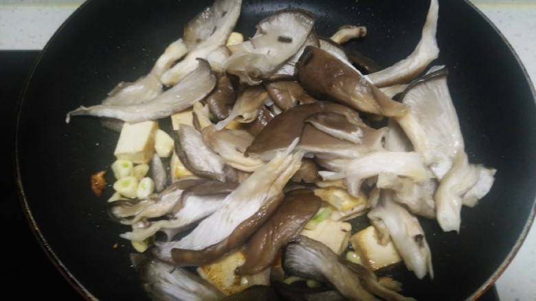 内酯豆腐炒平菇、鱼块,倒入平菇