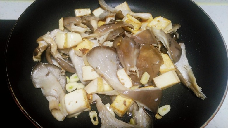 内酯豆腐炒平菇、鱼块,翻炒均匀