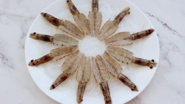 金蒜粉丝蒸海虾,依次把所有的海虾，都处理好以后，码放在粉丝上面。