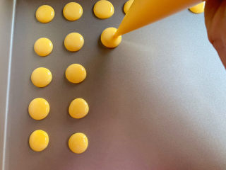 奶香蛋黄溶豆,剪个小孔，挤入不粘烤盘中，注意溶豆的空隙，避免粘连