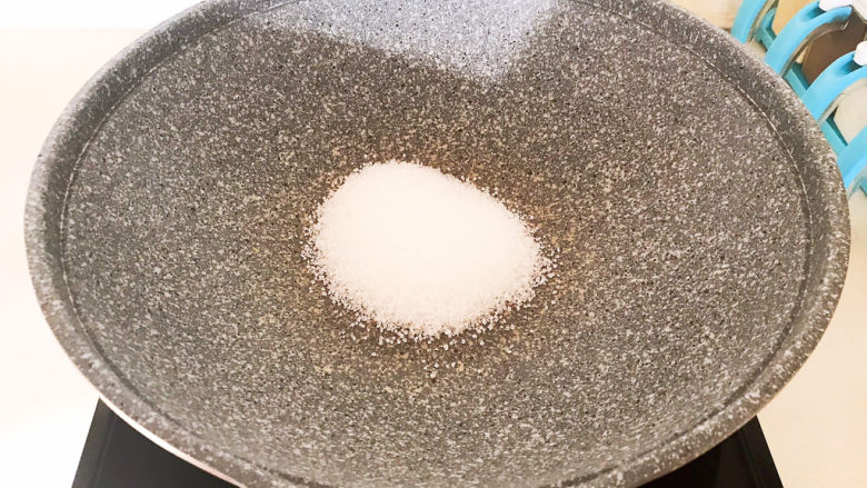 盐焗花生米,炒锅烧热后放入白砂糖，小火翻炒