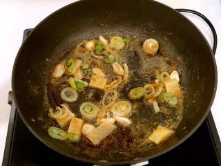 明虾煲,把葱花和姜丝放入锅里，利用锅里的余油煸炒葱花和姜丝，炒出香味