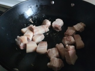 干豆角红烧肉,把五花肉直接倒入锅中煎制出油。