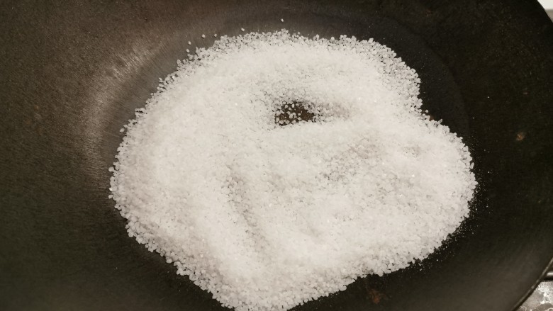 盐焗花生米,锅中放入腌制盐  加热