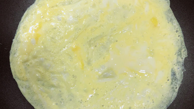 冬至美食 喜庆四喜蒸饺,锅中放入少量油，放入鸡蛋摊成很薄的饼状。