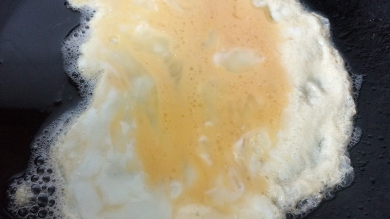 冬至美食  蛋饺,锅内放油烧热用勺子挖入两勺蛋液