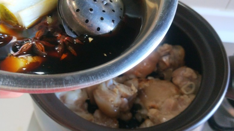 黄豆炖猪脚,在把盆中调料倒入锅中。