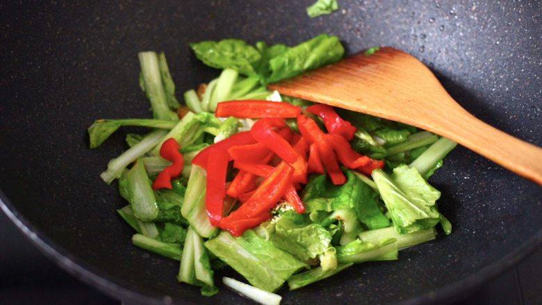 小白菜素炒香干,大火继续快速翻炒至小白菜断生变软时，加入红椒。