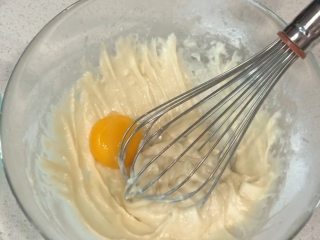 圣诞蛋糕卷,分离蛋清蛋黄，将蛋黄加入，再次用切拌手法充分拌均匀（蛋白此时可放入冰箱冷冻）。