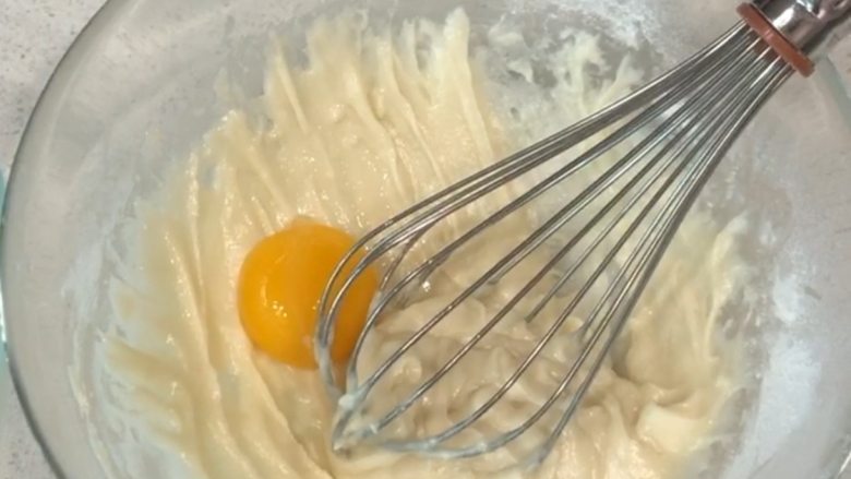 圣诞蛋糕卷,分离蛋清蛋黄，将蛋黄加入，再次用切拌手法充分拌均匀（蛋白此时可放入冰箱冷冻）。