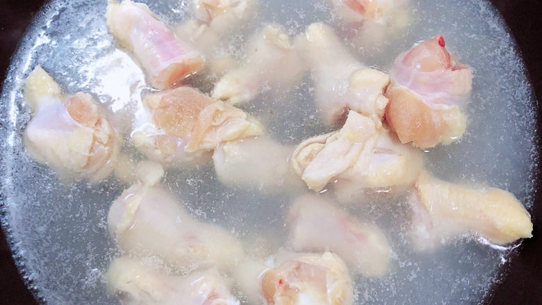 小鸡炖蘑菇粉条,锅中烧开水，放入鸡翅根焯一下血水。