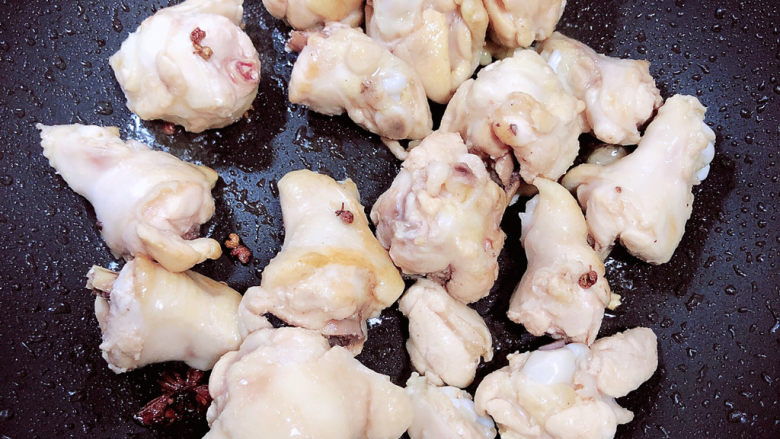 小鸡炖蘑菇粉条,放入鸡翅根翻炒均匀。