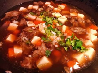 牛肉炖豆腐,最后撒上葱花和香菜提鲜即可出锅享用
