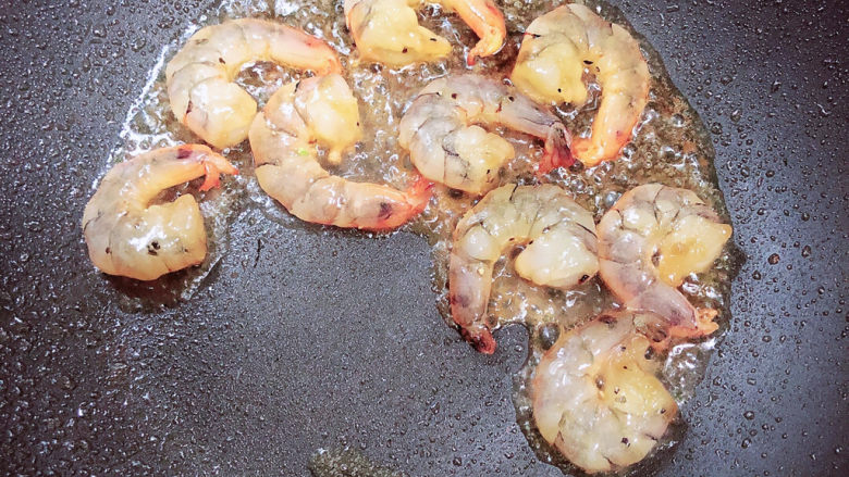 菠萝虾仁炒饭,锅中倒入油，烧至五成热，放入虾仁煎煮虾仁变成黄色。