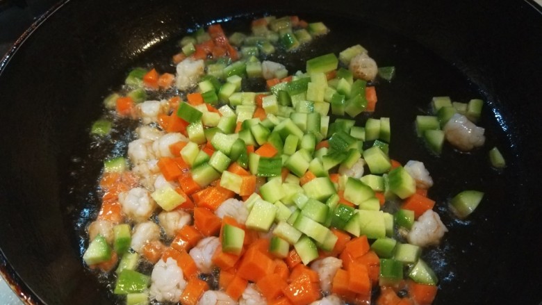 菠萝虾仁炒饭,倒入胡萝卜黄瓜炒均匀。