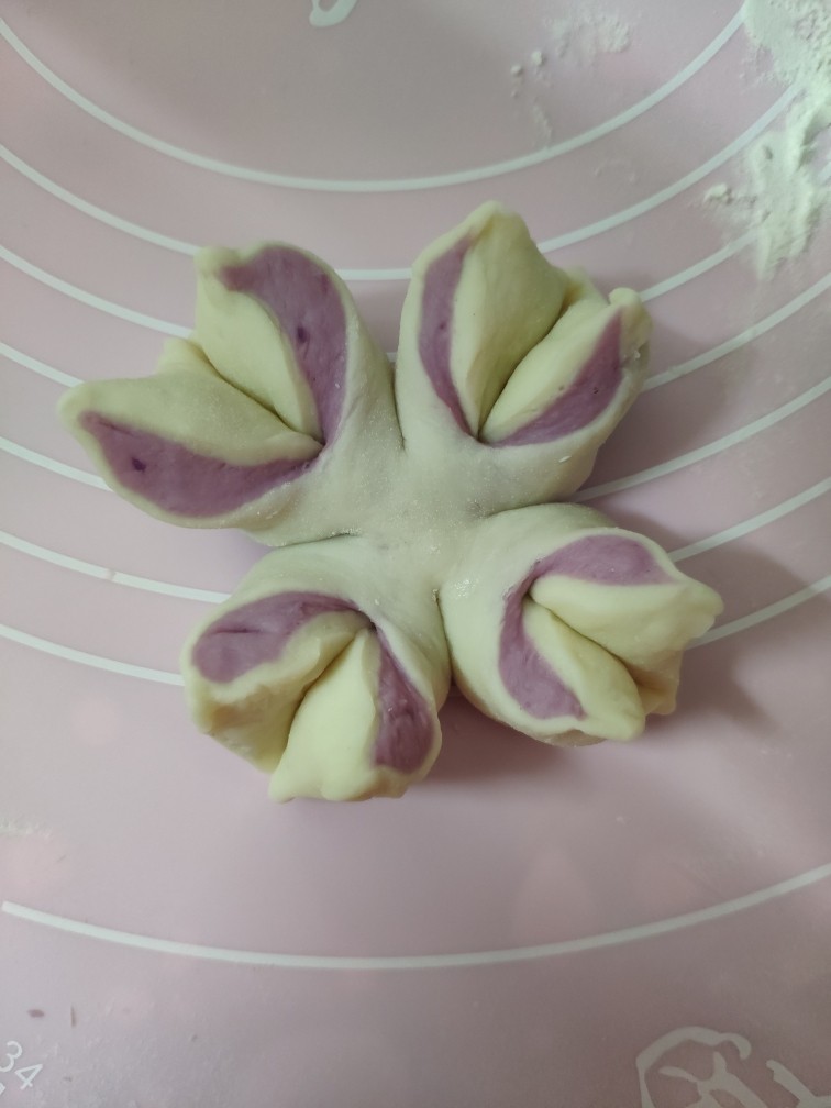 紫薯花朵馒头,两片花瓣一左一右向外转一下，底部捏紧就完成了