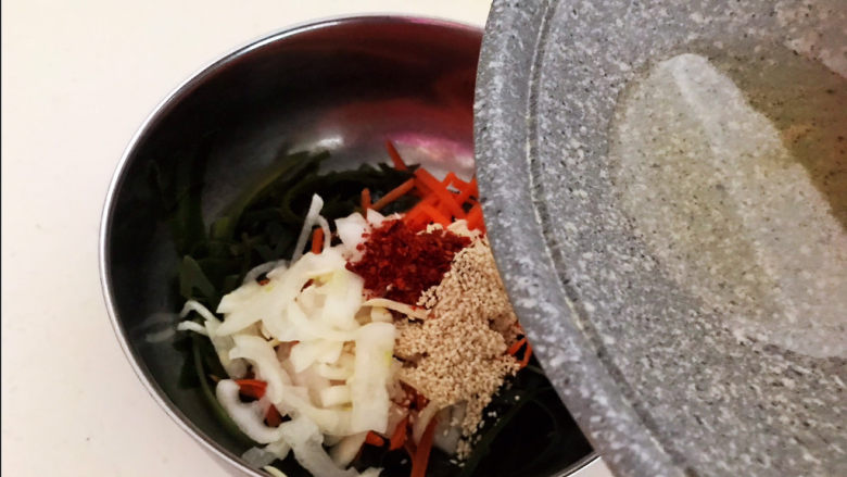 香辣海带丝,趁热把大豆色拉油倒入盆中，把大蒜和辣椒粉的香味激发出来