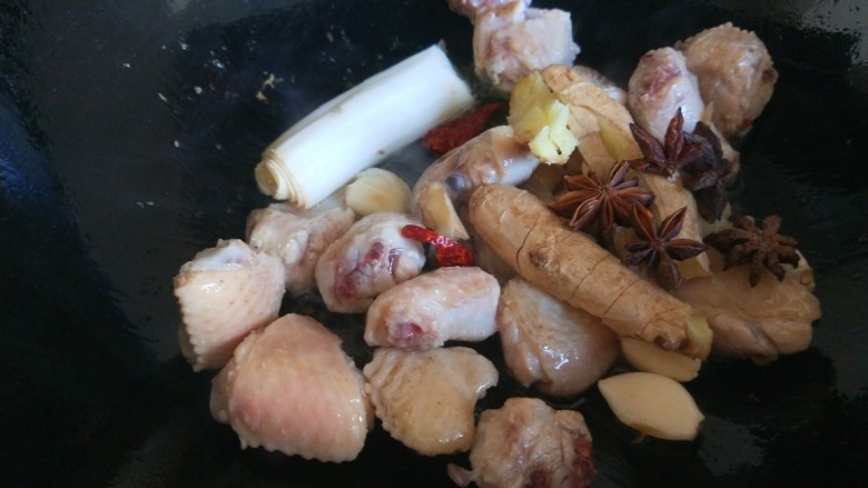 小鸡炖蘑菇粉条,倒入鸡块炒均匀，加入葱姜蒜炒香。