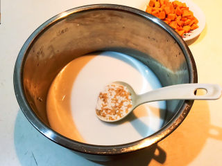 奶香南瓜粥,把浸泡后的米和牛奶液倒入锅里
