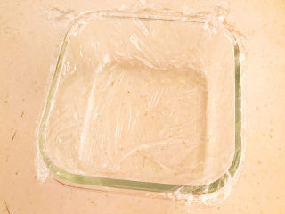 南瓜糯米糕,取一个耐高温的玻璃碗，在碗里铺上一层耐高温保鲜膜
