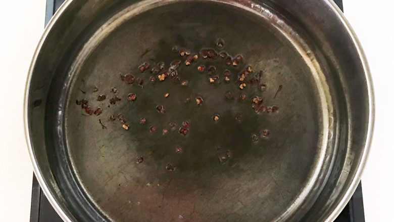 老坛酸菜鱼,油烧热后加入花椒粒，把花椒炒出香味，花椒油就做好了