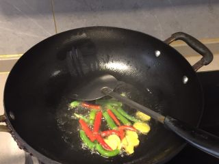 海椒干煸鸡翅,将姜片、青红海椒段下锅进行翻炒至有香味