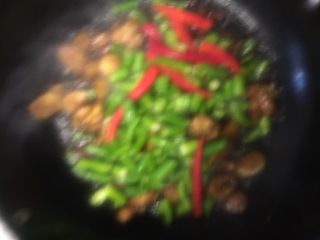 海椒干煸鸡翅,将煸炒好的鸡翅和炒香的红青海椒、姜片、葱段一起干煸