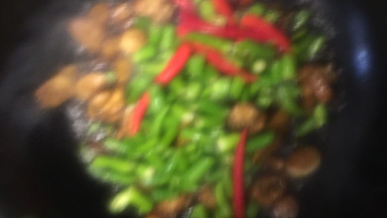 海椒干煸鸡翅,将煸炒好的鸡翅和炒香的红青海椒、姜片、葱段一起干煸