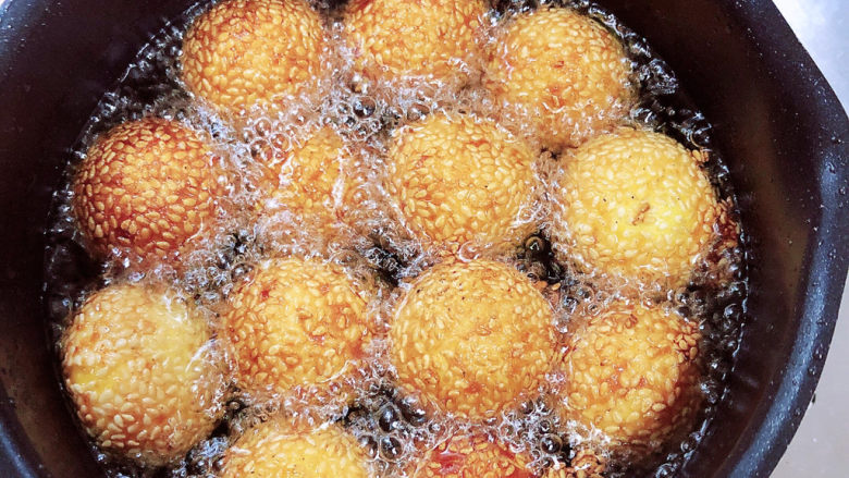 南瓜芝麻球,逐一放入南瓜球，南瓜球加热后慢慢漂起，炸至焦黄即可捞出控油。