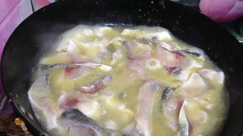 老坛酸菜鱼,
再用大火烧开鱼汤，将腌好的鱼片逐片放入汤中，晃动锅，鱼片变白成熟捞出放在碗上面