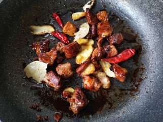 土豆牛腩煲,再加入干辣椒，八角，花椒和香叶翻炒均匀。