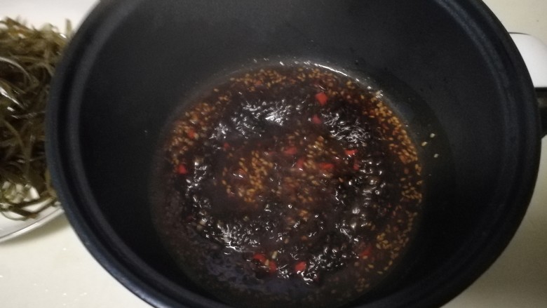 香辣海带丝,锅里放油，把腌制好的大蒜、生姜沫加入锅中，用油爆出香味