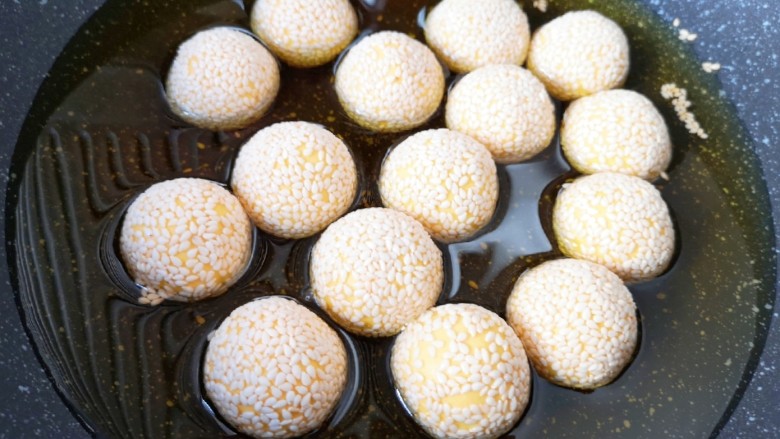 南瓜芝麻球,锅内放多一些调和油烧至七成热，下入南瓜芝麻球，中小火炸制。