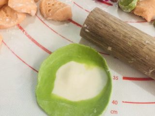 彩色水饺,每个都擀成近圆形薄片。记得撒点面粉在面皮上，避免互相粘连。