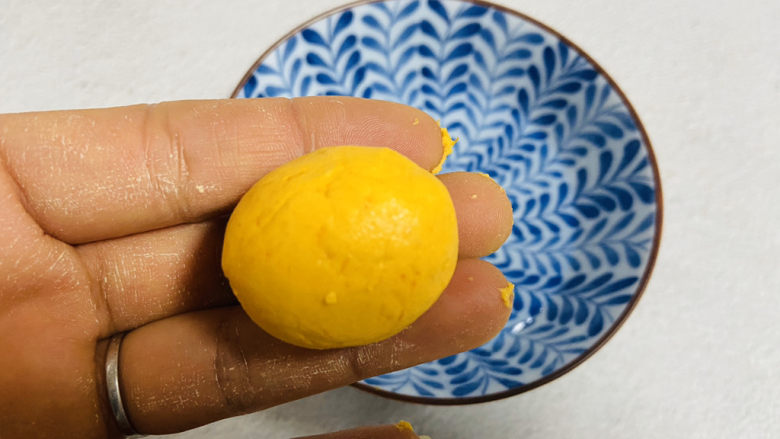 南瓜芝麻球,将面团分成大小均匀的小剂子，搓成小圆球沾点水