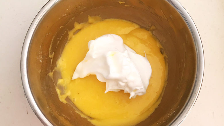 酸奶芝士蛋糕,取1/3蛋白霜放入蛋黄糊里面，快速翻拌均匀