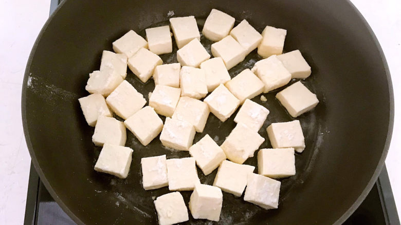  糖醋焦熘豆腐,油烧热后加入裹了面粉的豆腐块，小火煎制