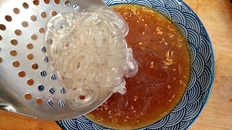 酸辣土豆粉,随即捞起放入盛着高汤的碗里。