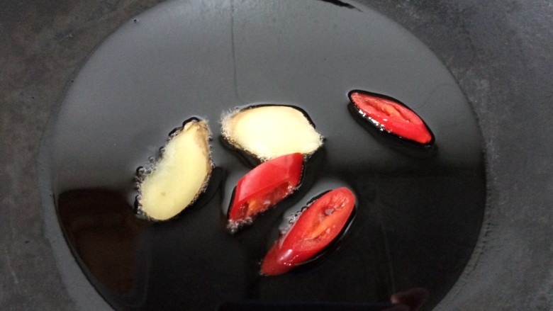 酱焖黄花鱼,锅内放油烧热，放入姜片、辣椒