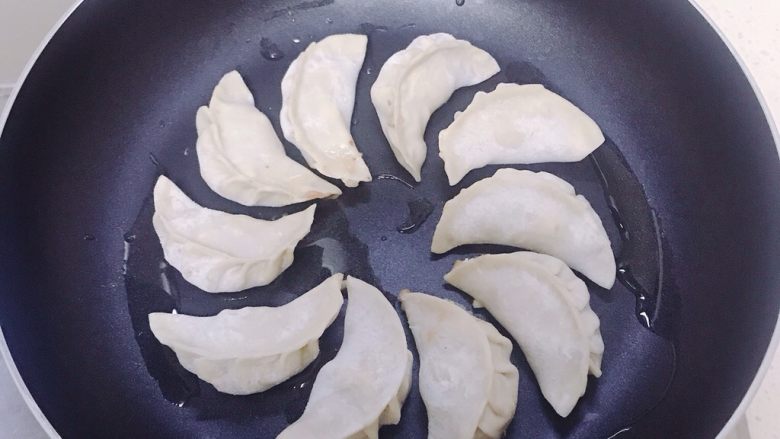 香菇虾仁饺子,锅里放少许油。码上包好的饺子。先煎一会儿。
