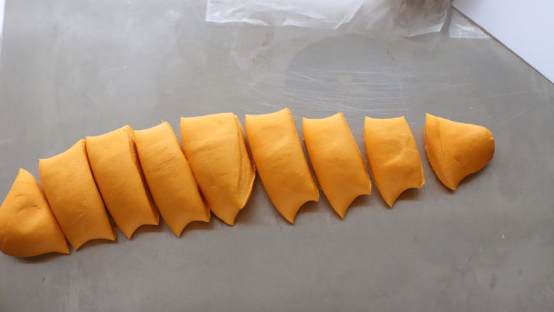 南瓜卡通馒头,将黄色面团揉成条状，分成50克左右均匀的小剂子。