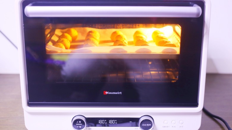 南瓜麻薯包,放入铺好油纸的烤盘，推入预热好的烤箱，180度烤25分钟即可。