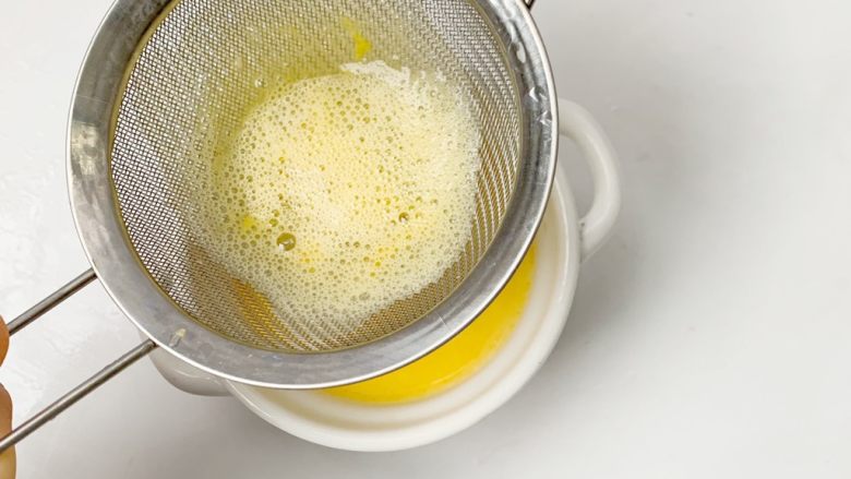 简单易学宝宝辅食：三文鱼Q弹蛋羹,过筛到蒸碗中（注：这一步一定要做、才能达到很Q弹的效果）浮沫很多的话，记得要撇去浮沫哦。
