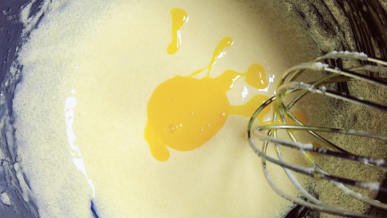 菠萝面包,分次加入鸡蛋液搅打均匀。