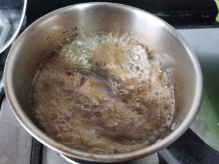 酱焖黄花鱼,锅里倒入半锅植物油，中火加热至六七成热。放入沥干水分的小黄鱼。炸至表面金黄后捞出。