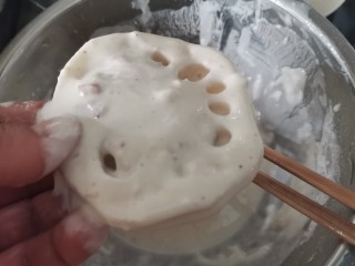 藕夹肉,把多余的面糊刮掉。面糊调制的状态就是能刚刚让藕挂住就好，太厚了炸出来也不好吃。