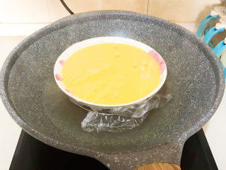 南瓜鸡蛋羹,锅里水开后把装有鸡蛋液的汤盘放在蒸屉上面