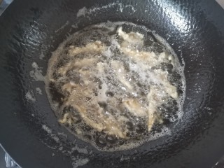 孜然蘑菇,下裹好的蘑菇炸，炸的时候用筷子轻轻搅动，防止粘在一起