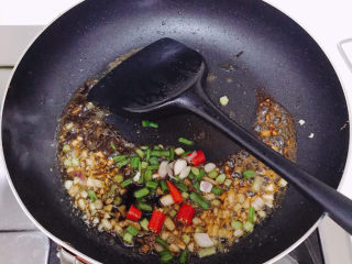 香煎鲫鱼,再加少许水。注意这里要一定要小火，加了酱油很容易焦。最后撒上小米辣和葱叶。