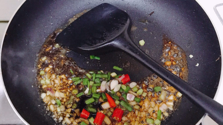 香煎鲫鱼,再加少许水。注意这里要一定要小火，加了酱油很容易焦。最后撒上小米辣和葱叶。